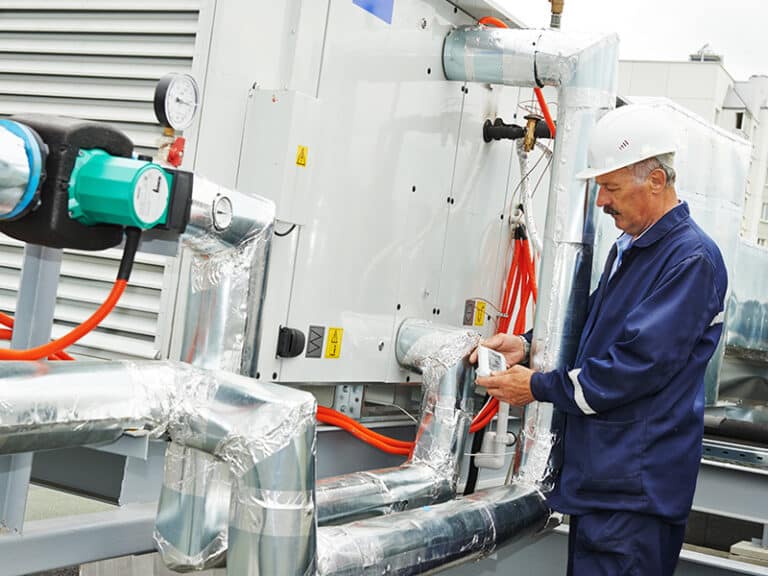 Technician installing ductwork and components in HVAC system