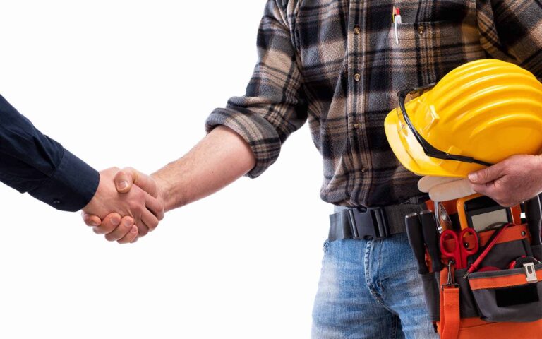 Construction worker shaking hands with business professional
