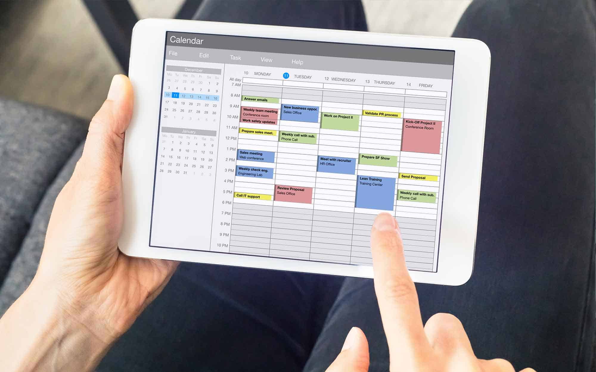 Project management calendar app on tablet showing weekly schedule with color-coded tasks