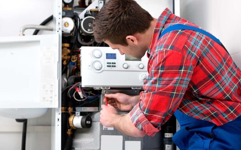 Technician inspecting HVAC system controls and heating equipment