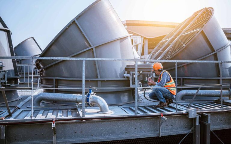 HVAC technician inspecting rooftop air conditioning unit during maintenance
