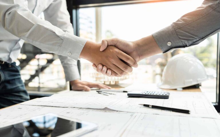 HVAC technician and customer shaking hands over maintenance agreement contract
