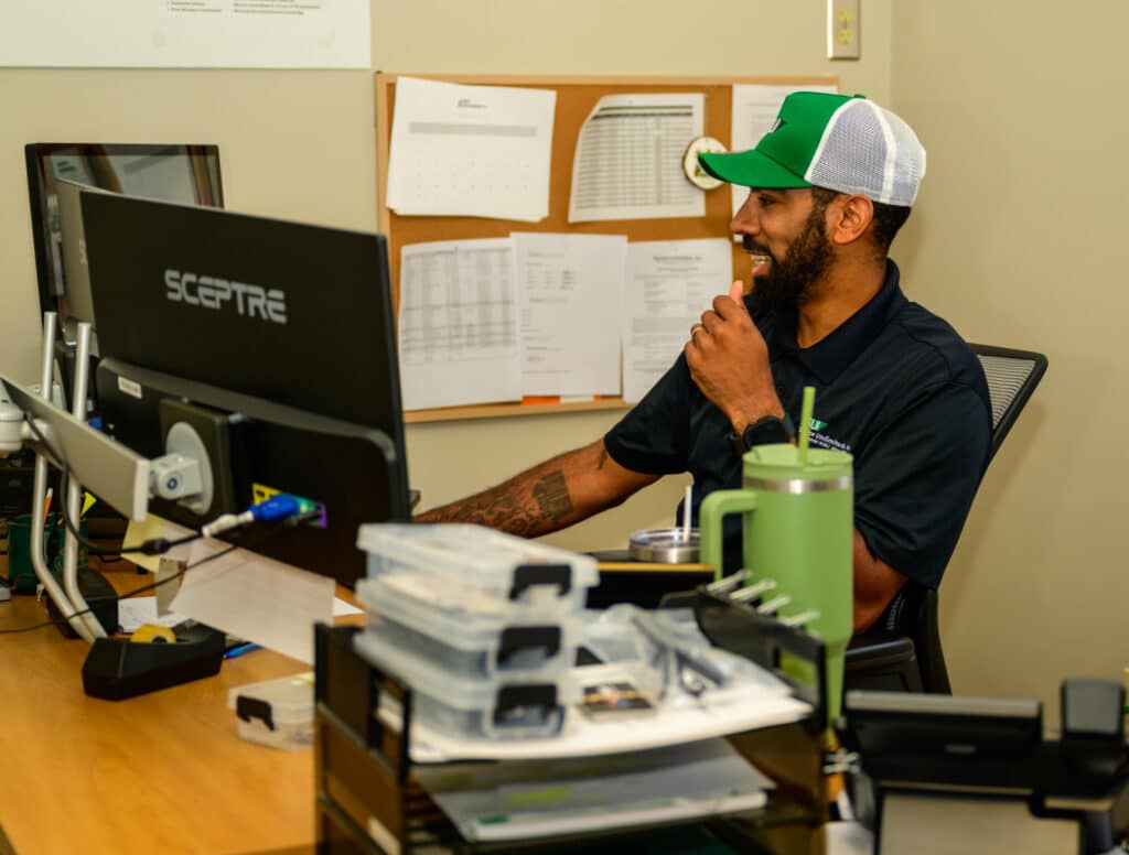 Employee working at desk with computer in organized office workspace