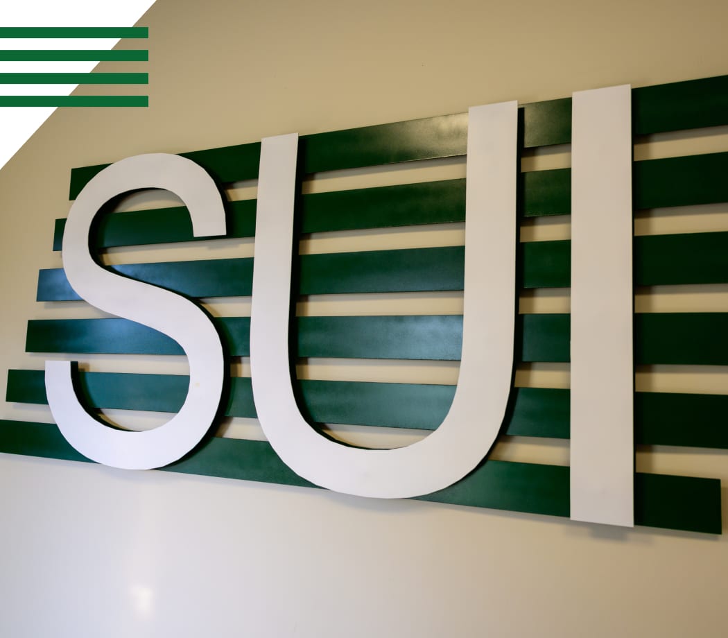 Service Unlimited Inc SUI white logo sign on striped green wall