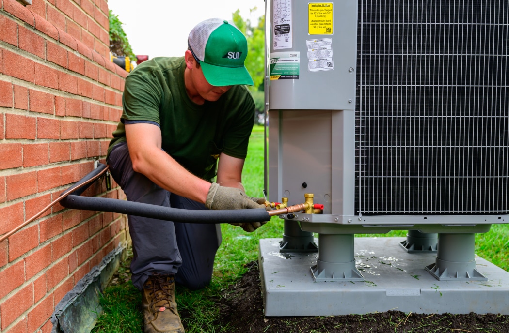 Service Unlimited technician performing commercial HVAC maintenance on exterior unit