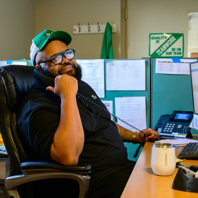 HVAC service technician at desk with quality assurance materials