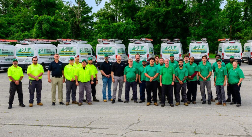 Service Unlimited team members standing in front of company service vehicles