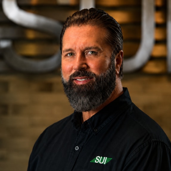 Service Unlimited team member in black SUI polo shirt at facility