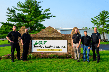 Service Unlimited, Inc. team members standing by company sign outdoors