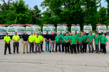 Service Unlimited team members standing in front of company service vehicles
