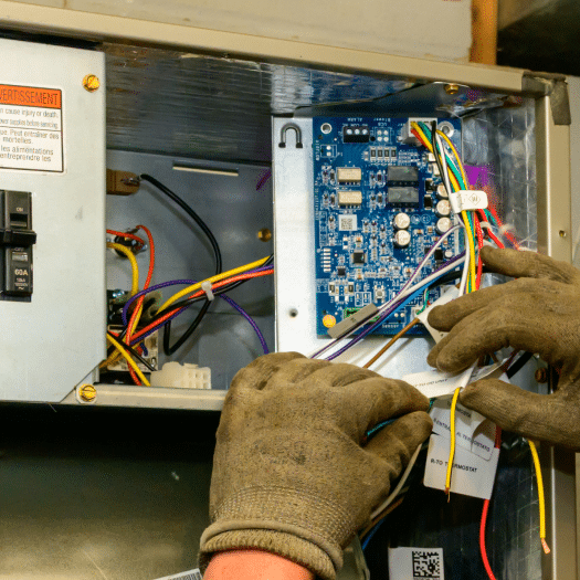 Technician inspecting HVAC circuit board during repair service