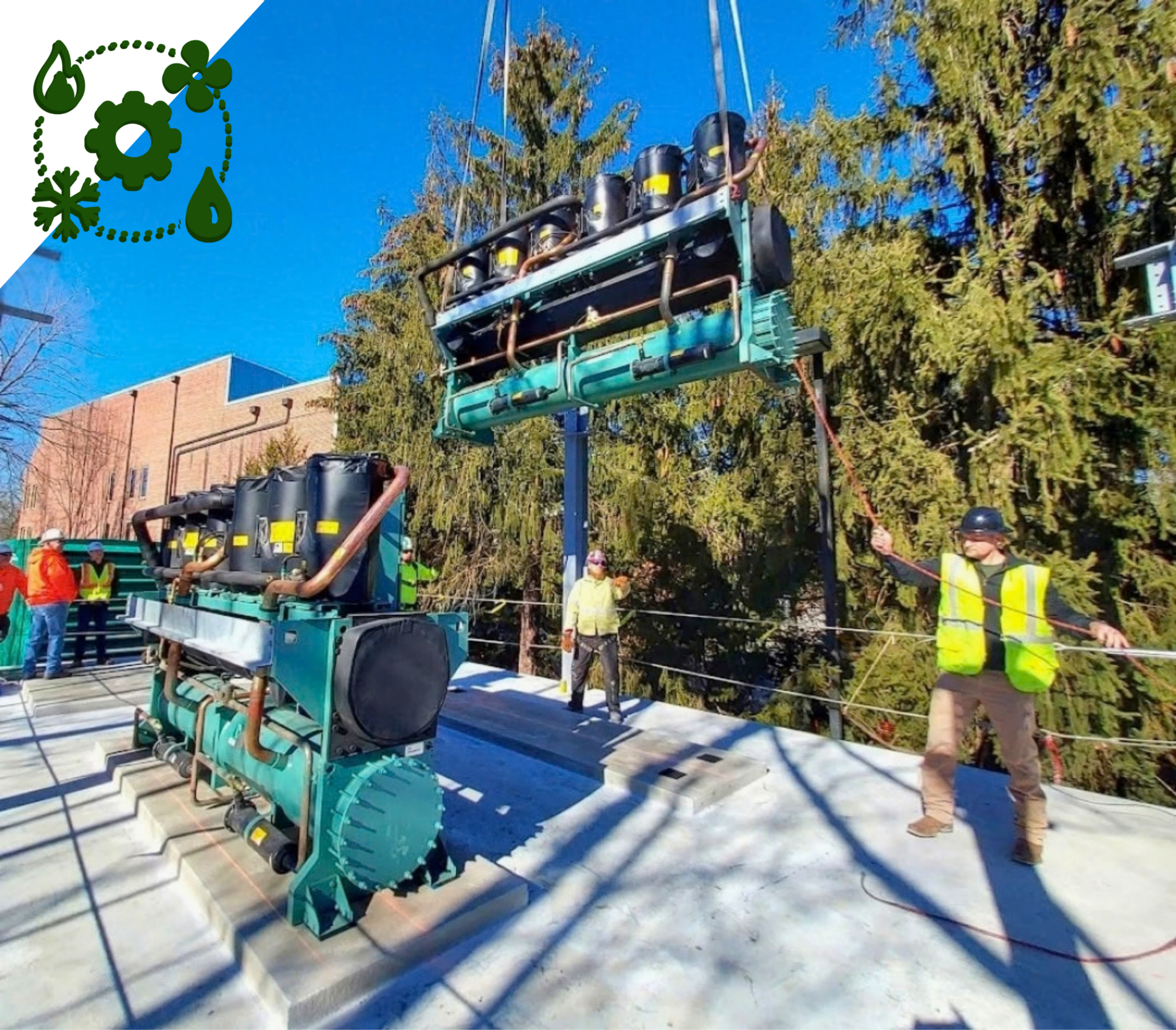 Phoot of technicians in safety vests monitoring a crane being used to life an hvac component